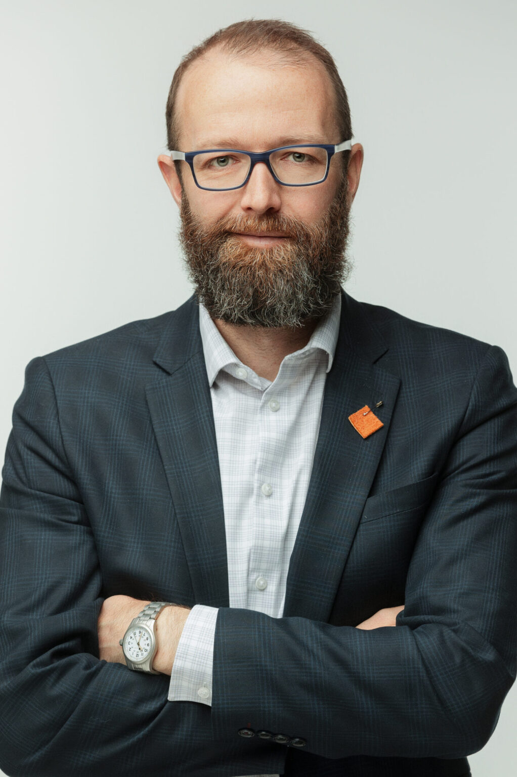 portrait of Kyle Hamilton, posed wearing a suit, with arms crossed, looking like Fernie's next Mayor.
